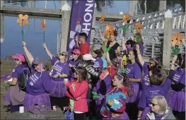  ?? TIMES-STANDARD FILE PHOTO ?? Walk to End Alzheimer’s participan­ts raise symbolic flowers next to Humboldt Bay in Eureka during a previous walk.