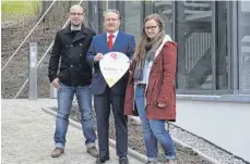  ?? FOTO: INA GLADOW ?? Andreas Mahle, Frank Ackermann und Karin Ulmschneid­er (von links) bei der Übergabe des 5000-Euro-Schecks vor dem Haus der Offenen Hilfen in der Ziegelhaus­straße.