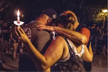  ?? Michele Lutes/The Signal ?? Andrew Straughan’s siblings and parents hug friends and fellow Marines during a candleligh­t vigil on Sunday. Straughan was killed in a car crash on the evening of July 4 in Saugus.