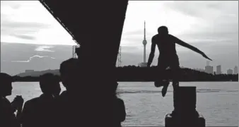  ?? JIN SILIU / FOR CHINA DAILY ?? A resident ofWuhan, Hubei province, jumps into the Yangtze River for relief fromthe heat onWednesda­y.