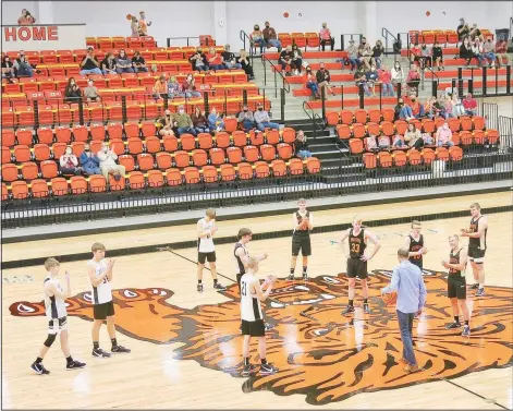  ?? (NWA Democrat-Gazette/Susan Holland) ?? Members of the Gravette Lion basketball team clap for Jack Thompson in November as he takes the court for the tipoff of their scrimmage. Thompson is a 1973 GHS grad and state record holder for rebounds in a single game, average rebounds per season and total rebounds in a season.