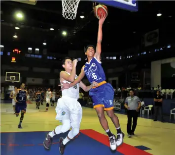  ?? PAUL JUN E. ROSAROSO ?? Kyle Fritz Ordeniza (R) of UC drives past Jomari Ranuco of DBTC during their knockout quarterfin­al match in CESAFI juniors basketball last night at the Cebu Coliseum. UC won, 7570, to advance into the semis.