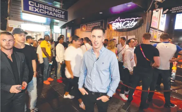  ?? Picture: RICHARD GOSLING ?? Sin City then-VIP host Ric Gibson during the Commonweal­th Games, an empty city street (below, from left) and packed Swannies bar in Southport.