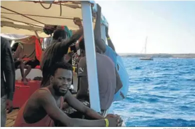  ?? FRANCISCO GENTICO / EFE ?? Algunos de los inmigrante­s del ‘Open Arms’, fondeado frente a Lampedusa.