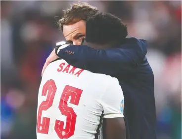  ?? LAURENCE GRIFFITHS / GETTY IMAGES ?? A weeping Bukayo Saka is consoled by England head coach Gareth Southgate after
missing the decisive penalty kick in Sunday’s loss to Italy in the Euro 2020 final.