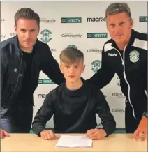  ??  ?? Oscar MacIntyre ready to sign his pro-youth form for Hibernian watched by his dad Boyd and Hibs coach Gareth Evans.