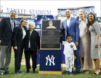  ?? KATHY WILLENS — THE ASSOCIATED PRESS ?? Retired Yankees shortstop Derek Jeter, third from right, poses with members of his family during a pregame ceremony retiring his No. 2 in Monument Park at Yankee Stadium on Sunday.