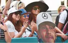  ?? Virendra Saklani/Gulf News ?? Hamilton fans show their support during the pit lane walk at the Yas Marina Circuit yesterday.