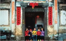  ??  ?? Children eating ice cream as they await a dragon parade in Peitian village.