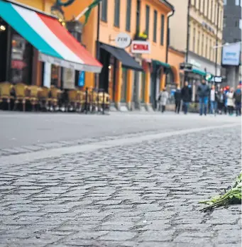  ??  ?? Trotz der Warnungen der Polizei kamen viele Bürger in die Stockholme­r Innenstadt und legten Blumen und K