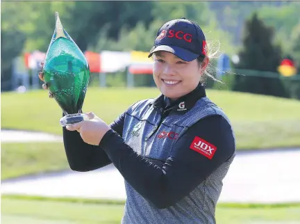  ?? VAUGHN RIDLEY/GETTY IMAGES ?? Ariya Jutanugarn smiles while holding the trophy after sinking a birdie putt on the first playoff hole to win the Manulife LPGA Classic at Whistle Bear Golf Club on Sunday in Cambridge, Ont. The three-way playoff included Lexi Thompson and In Gee Chun.