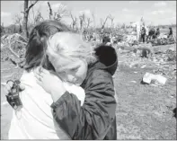  ?? By Tom Dorsey, Salina (Kan.) Journal, via AP ?? Comforting: Sara Shogren, left, hugs Zoey Patrick as friends sort through the rubble of Patrick’s home Sunday in Marquette, Kan.