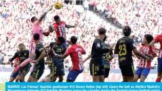  ?? ?? MADRID: Las Palmas’ Spanish goalkeeper #13 Alvaro Valles (top left) clears the ball as Atletico Madrid’s Mozambican defender #23 Reinildo Mandava jumps for a header during the Spanish league football match on February 17, 2024. — AFP