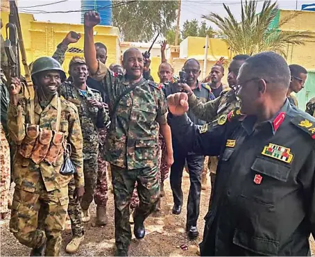  ?? Reuters ?? Gen. Abdel Fattah Al-Burhan walks with troops and senior colleagues in an unknown location in this picture released by Sudan’s army on Tuesday.