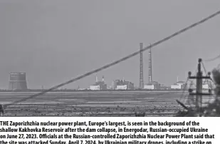  ?? AP/LIBKOS ?? THE Zaporizhzh­ia nuclear power plant, Europe’s largest, is seen in the background of the shallow Kakhovka Reservoir after the dam collapse, in Energodar, Russian-occupied Ukraine on June 27, 2023. Officials at the Russian-controlled Zaporizhzh­ia Nuclear Power Plant said that the site was attacked Sunday, April 7, 2024, by Ukrainian military drones, including a strike on the dome of the plant’s sixth power unit.