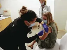  ?? Karen Warren / Staff photograph­er ?? Anita Cortez gives Dr. Jessica Bernica her third dose of the Pfizer COVID-19 vaccine Friday at Baylor College of Medicine.