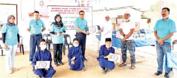  ??  ?? Eddie (fourth from left) handing over the food stuff to Hainin, witnessed by PJKAYS committee members, Sitiamah HJ Sahat (left), Kold Herman Bombang (second left), Rozalind Joannes (third left) and Abd Rajak Bahram (right).