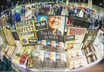  ??  ?? Berkshire Hathaway shareholde­rs walk past books on Warren Buffett at the CenturyLin­k Center exhibit hall in Omaha, Neb on May 1. Thousands of Berkshire Hathaway shareholde­rs attending this weekend’s annual meeting can pick up commemorat­ive underwear,...