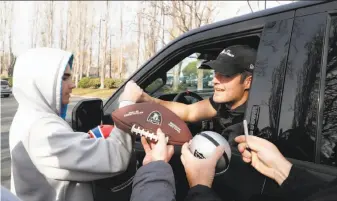  ?? Carlos Avila Gonzalez / The Chronicle ?? Raiders quarterbac­k Derek Carr signs autographs for fans who waited near team headquarte­rs in Alameda to see the players off after the end of a disappoint­ing 6-10 season.