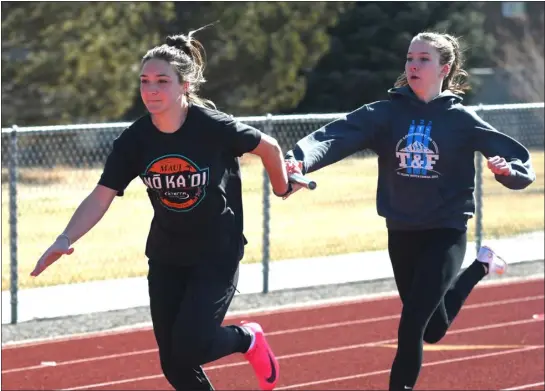  ?? PHOTOS BY NATHAN WRIGHT — LOVELAND REPORTER-HERALD ?? Berthoud’s Ellie Harper, left, takes a handoff from Madison Kenner during track practice last week at BHS.