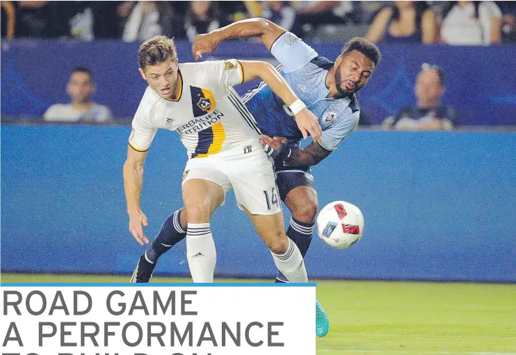  ?? — GARY A. VASQUEZ/USA TODAY SPORTS ?? Los Angeles Galaxy forward Robbie Rogers battles Vancouver Whitecaps FC midfielder Giles Barnes during MLS action Saturday night in L.A.