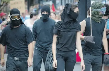  ?? Peter Mccabe, The Canadian Press ?? Young people dressed in the Black Bloc style clothing join a protest in Montreal on Sunday.