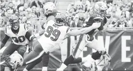  ?? MADDIE MEYER GETTY IMAGES ?? J.J. Watt of the Houston Texans attempts to tackle quarterbac­k Tom Brady, right, of the New England Patriots on Sunday in Foxborough, Mass. The Patriots won, 27-20.