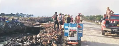  ??  ?? BESAUP: Raban pengerara api enggau pekereja ladang nya besaup ngerara api ti nganguska Ladang Sawit Felcra di Bunut.