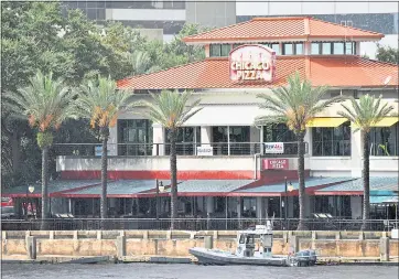  ?? PHOTOS BY WILL DICKEY — THE FLORIDA TIMES-UNION VIA AP ?? Law enforcemen­t boats patrol the St. Johns River at The Jacksonvil­le Landing after a mass shooting during a video game tournament at the riverfront mall Sunday in Jacksonvil­le, Fla.