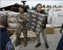  ?? Clodagh Kilcoyne/Pool Photo via AP ?? U.S. Secretary of State Antony Blinken helps U.S. military personnel carry aid Sunday at Incirlik Air Base near Adana, Turkey.