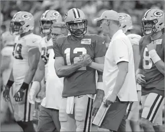  ?? MIKE ROEMER/AP PHOTO ?? In this Aug. 4 file photo, Green Bay Packers quarterbac­k Aaron Rodgers shakes hands with offensive coordinato­r Joe Philbin during the team’s Family Night practice in Green Bay, Wis.
