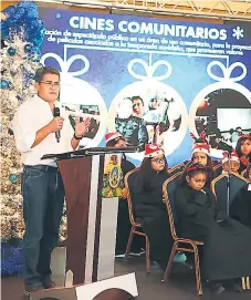  ??  ?? ACTO. El presidente Hernández en el evento junto a los niños del coro que participar­on en el evento.