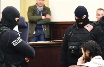  ?? EMMANUEL DUNAND/AFP ?? Prime suspect in the November 2015 Paris attacks Salah Abdeslam sits as he is surrounded by Belgian special police officers in the courtroom in Brussels for the opening of his trial, yesterday.