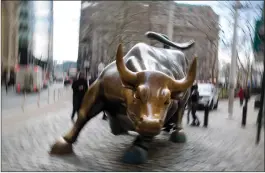  ?? Bloomberg photo by Michael Nagle ?? The famous bull sculpture stands near Wall Street in New York.