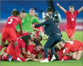  ?? The Canadian Press ?? Canada’s coach Bev Priestman celebrate with her players after defeating Sweden in the women’s soccer match for the gold medal at the 2020 Summer Olympics, Aug. 6, 2021, in Yokohama, Japan.