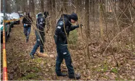  ?? Photograph: Mindaugas Kulbis/AP ?? Police officers search near the home of Leonid Volkov after the brutal attack on him last week.