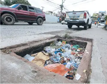  ?? FOTO: DAVID ROMERO ?? Residentes de Prados Universita­rios aseguran que el tragante de aguas lluvias tiene meses de permanecer colmado de basura.