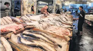  ?? PHOTO: REUTERS ?? Vendors wait for customers at a fish market near the canal of Port Said, Egypt.