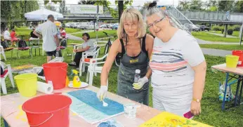  ?? FOTOS: SIMON SCHNEIDER ?? Unter der Leitung von Marion Bernhardt (rechts) gestaltet am Samstag Elke Gerhardt im Garten Momo an der Donau ein Bild mit Acrylfarbe­n.