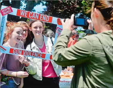  ?? SARAH GORDON/THE DAY ?? Anastacia Riordan, left, of Montville, poses for a photo with friends Annelise Adams, center, and Kayleigh Adams, of Waterford, during a Wear Orange event on Sunday at the Niantic Town Green.