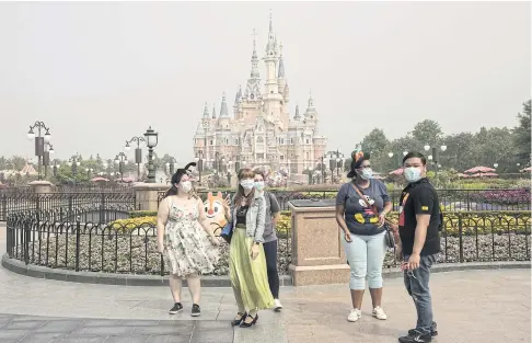  ?? BLOOMBERG ?? Visitors stand in front of the Enchanted Storybook Castle during the reopening of the Shanghai Disneyland yesterday.