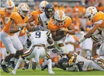  ?? STAFF PHOTO BY ERIN O. SMITH ?? Tennessee running back Jeremy Banks (33) pushes through the ETSU defense during the second half of the Vols’ 59-3 win last Saturday in Knoxville. Banks rushed for two touchdowns and 62 yards on 13 carries.