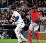  ?? KEVIN C. COX / GETTY IMAGES ?? Pedro Severino (right) of the Washington Nationals catches Preston Tucker of the Braves in a rundown Monday at SunTrust Park.