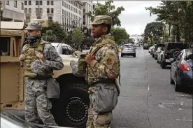  ?? JACQUELYN MARTIN / AP ?? Members of the D.C. National Guard block an intersecti­on on 16th Street as demonstrat­ors gather Tuesday to protest the death of George Floyd.