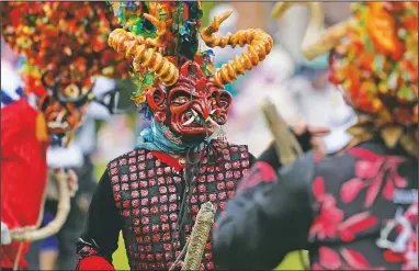  ?? (AP/Dolores Ochoa) ?? People dressed as devils dance in La Diablada Pillarena amid the covid-19 pandemic in Pillaro, Ecuador. Performers took to the streets of this small city in the center of the country with only 30 characters dancing in a closed place and without an audience.