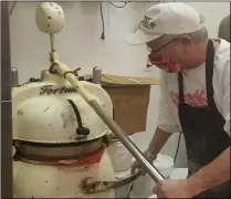  ??  ?? Tim Kiedrowski presses and rolls out paczki dough in the business’s Fortuna machine Feb. 4.