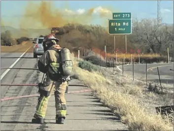  ?? TUCSON FIRE DEPARTMENT ?? IN THIS PHOTO PROVIDED BY THE TUCSON FIRE DEPARTMENT, personnel work to control the hazardous material leak and brush fire incidents at Rita Rd. and Interstate 10 near Tucson on Tuesday.