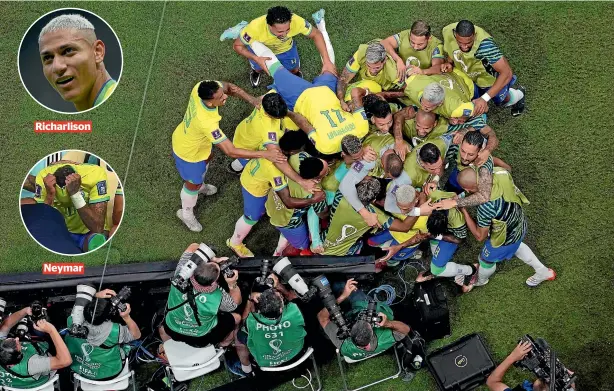  ?? GETTY IMAGES ?? Brazilian players and substitute­s swarm over two-goal hero Richarliso­n during the 2-0 win over Serbia at the World Cup in Lusail, Qatar, yesterday. It wasn’t such a happy night for superstar forward Neymar, who was in tears on the bench after leaving the field injured.