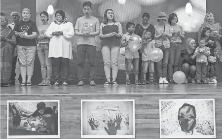  ??  ?? Relatives of victims of Malaysia Airlines flight MH370 hold candles at a remembranc­e ceremony. FAZRY ISMAIL/EPA-EFE