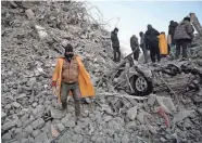  ?? OZAN KOSE/AFP VIA GETTY IMAGES ?? A relative walks in the rubble of collapsed buildings as rescue teams continue to search for victims and survivors after a 7.8 magnitude earthquake struck the border region of Turkey and Syria, in Kahramanma­ras, Turkey, Sunday.